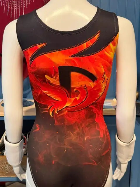 A black and fiery orange flame-patterned leotard with a bold ’d’ logo, designed for gymnastics or dance performance.